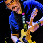 Foto do guitarrista Roberto Lessa usando chapéu e tocando uma guitarra Fender Telecaster